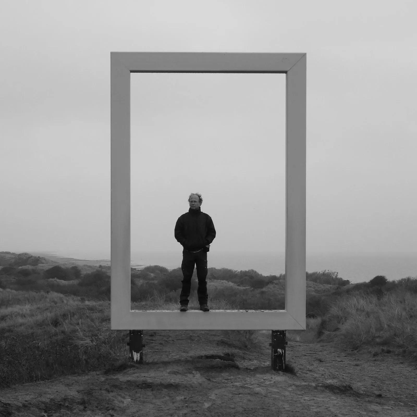 Pieter staat in een grote lijst midden in de duinen, met de zee achter hem